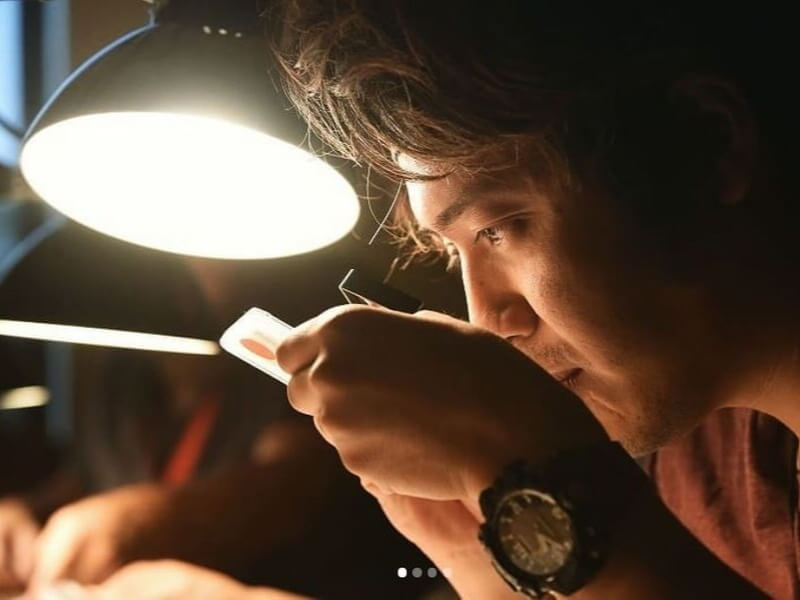 young man studying coin